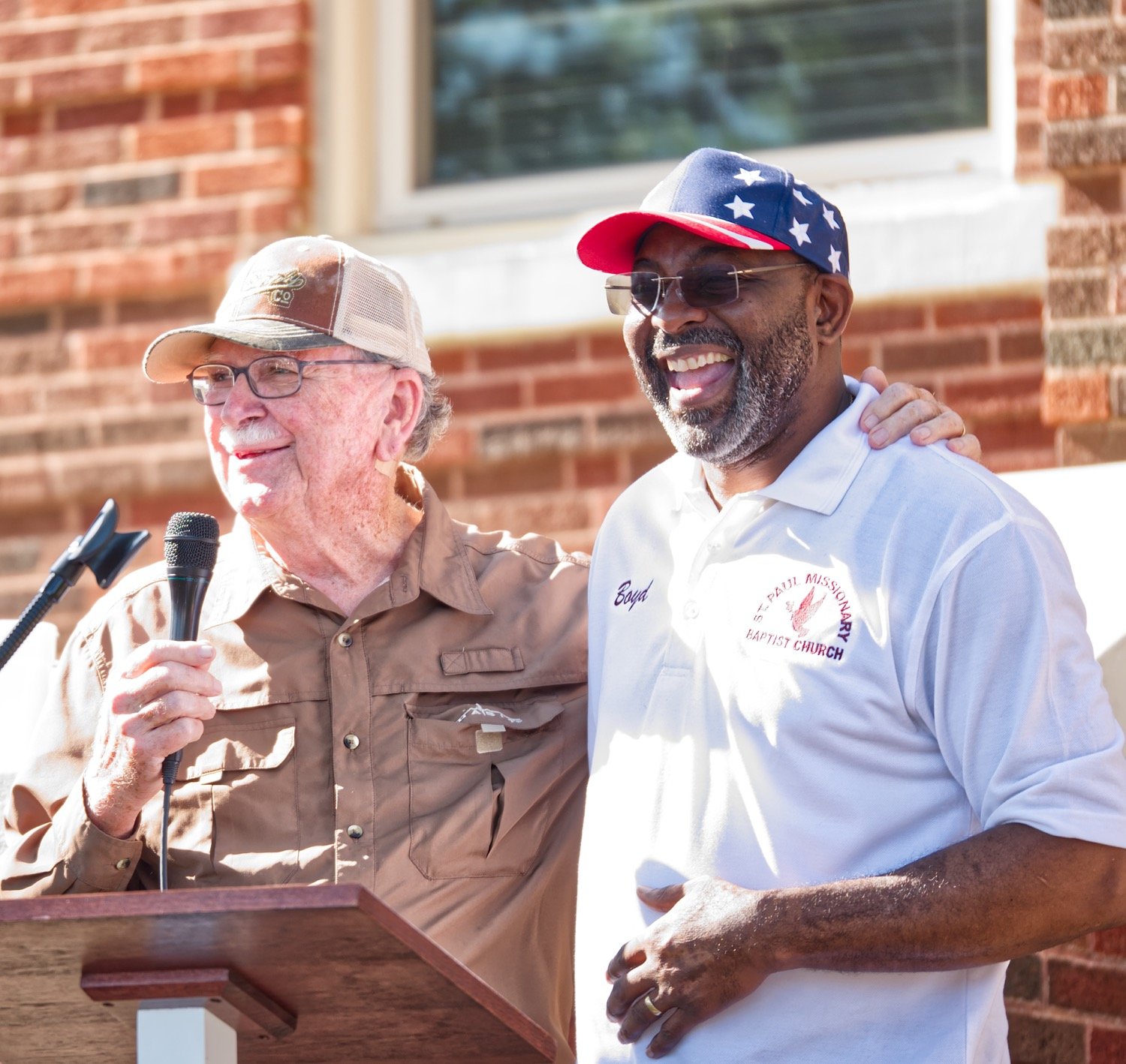 Pastors Jim Clark and Demethrius Boyd have a lighter moment during the prayer service Saturday morning at the county courthouse in Quitman.